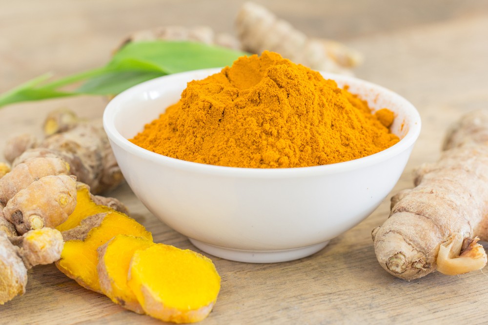 Bowl of bright  orange  turmeric powder