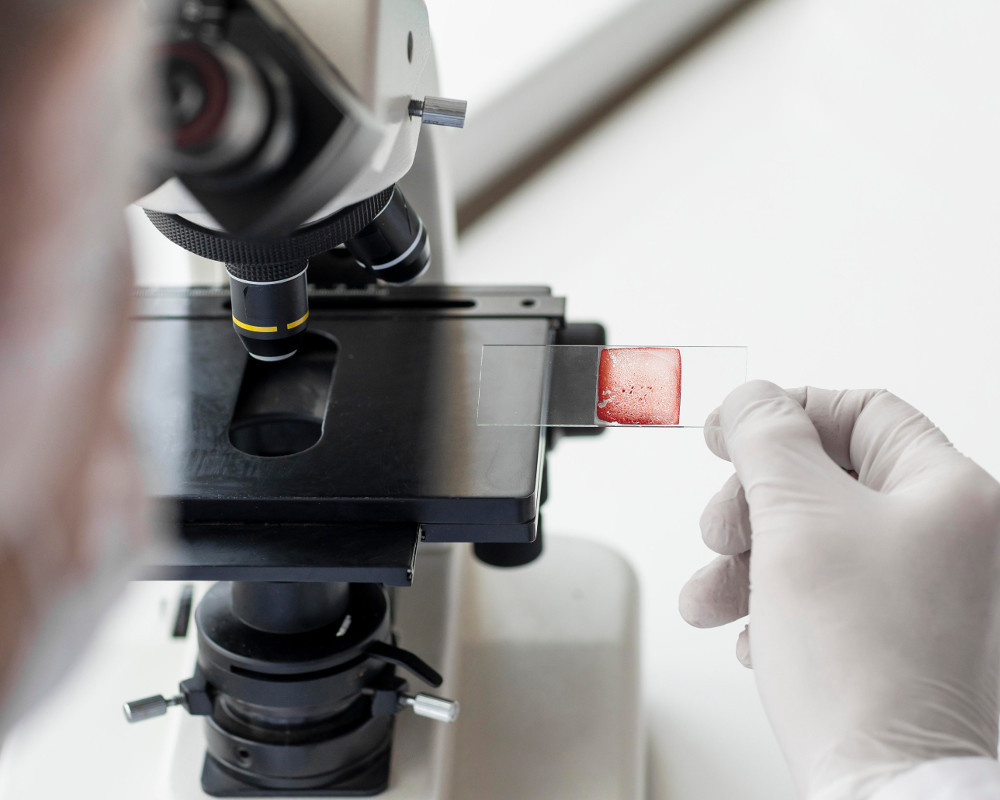 image of scientist looking down a microscope